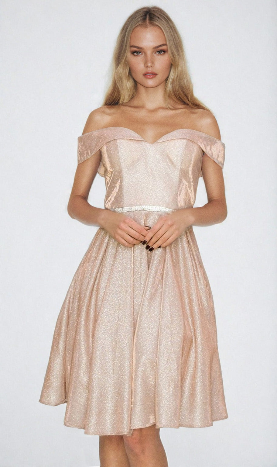 A woman stands against a plain light background, wearing the Off-Shoulder Short Glitter Homecoming Dress 8012J in light pink—a knee-length, shimmery gown.